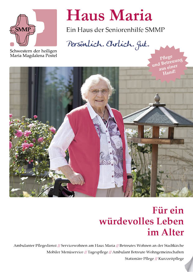 Broschüren & Flyer 4 Seniorin mit weißem Haar und pinker Weste, die sich auf einen Gehstock stützt, steht vor einem blühenden Rosenstrauch neben einem hölzernen Vogelhaus im Garten